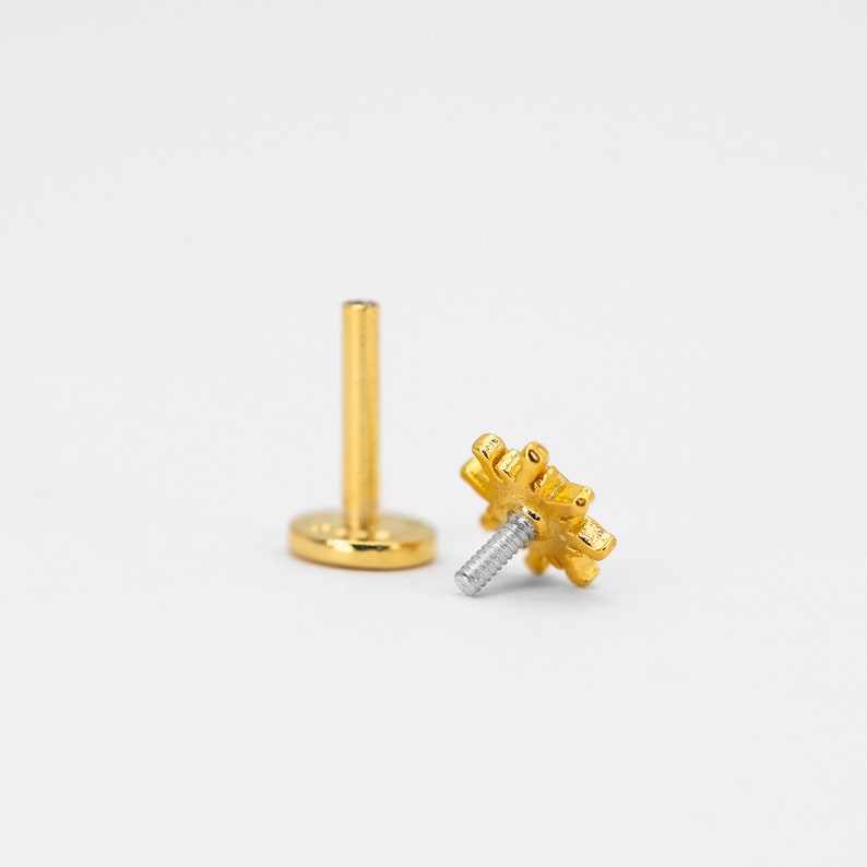 Op de afbeelding: Gouden sneeuwvlok lichaamsieraad met een schroefpost. De sieraden zijn gemaakt van chirurgisch staal en zijn geschikt voor lip-, wenkbrauw- of kraakbeenpiercings.