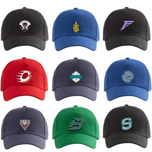 Op de afbeelding: Een collectie van negen baseballpetten in diverse kleuren, waaronder zwart, blauw, rood, grijs en groen. Elke pet is voorzien van een uniek geborduurd of geprint sportteamlogo op het voorpaneel, waaronder ontwerpen voor Detroit, Sirens en Vancouver.