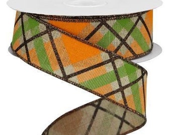May include: A spool of decorative ribbon with a plaid pattern in orange, green, and tan, accented with dark brown lines. The ribbon is on a white spool, with a portion unrolled and spiraling downward.