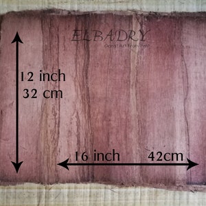 May include: A piece of brown papyrus paper with a reddish-brown stain. The paper measures 12 inches by 16 inches, or 32 cm by 42 cm. The text "ELBADRY Great Art From Past!" is printed on the paper.