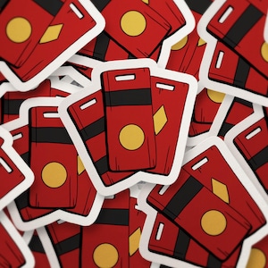 May include: A collection of red stickers with a white border. Each sticker features a rectangular design with a black stripe, a yellow circle, and a yellow diamond shape. The stickers are scattered across the image.