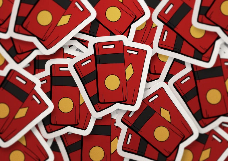 May include: A collection of red stickers with a white border. Each sticker features a rectangular design with a black stripe, a yellow circle, and a yellow diamond shape. The stickers are scattered across the image.