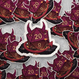 May include: A sticker sheet featuring multiple stickers of a burgundy D20 die with devil horns and a red arrow. The die has the numbers 20 and 8 visible. The stickers are designed for tabletop role-playing games.
