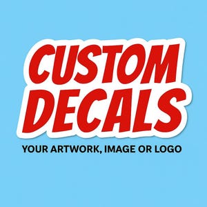 May include: White sticker with red text that says "CUSTOM DECALS" and the phrase "YOUR ARTWORK, IMAGE OR LOGO" below.