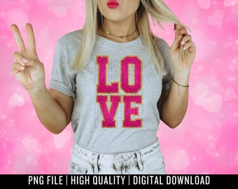 May include: A woman wearing a grey t-shirt with the word "LOVE" in pink glitter letters. The letters have a gold outline.