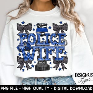 May include: White sweatshirt with a blue and black graphic design that says "Police Wife". The graphic includes a police badge, a bow, and stars.