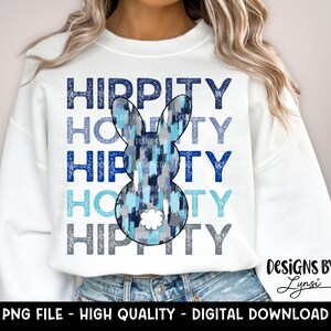 Może przedstawiać: Biała bluza z napisem "Hippity" powtórzonym cztery razy w kolorze niebieskim i szarym. Na środku bluzy znajduje się niebieski i szary królik z białym nosem.