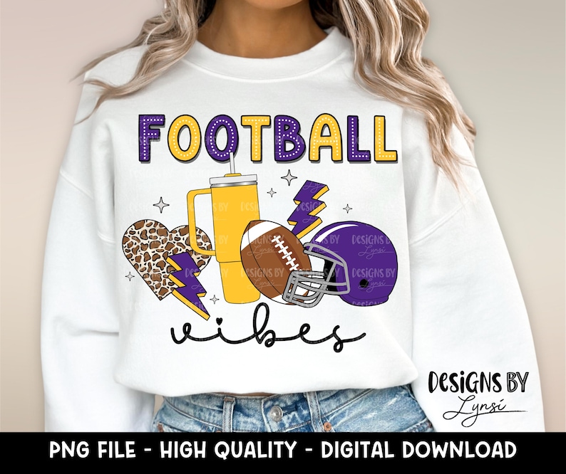 Pu&ograve; includere: Felpa bianca con un design viola e giallo che dice "FOOTBALL vibes". Il design include un pallone da calcio, un cuore, un fulmine e una tazza.