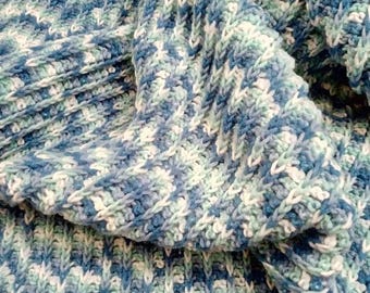 May include: A blue, white, and green crocheted blanket with a textured pattern.