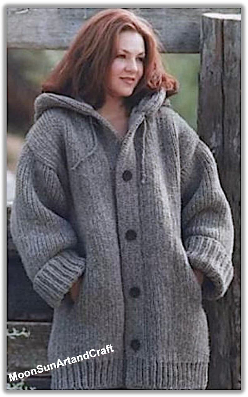 May include: A gray knitted cardigan with a hood and button closure. The cardigan has a ribbed texture and is made of a soft, warm material.