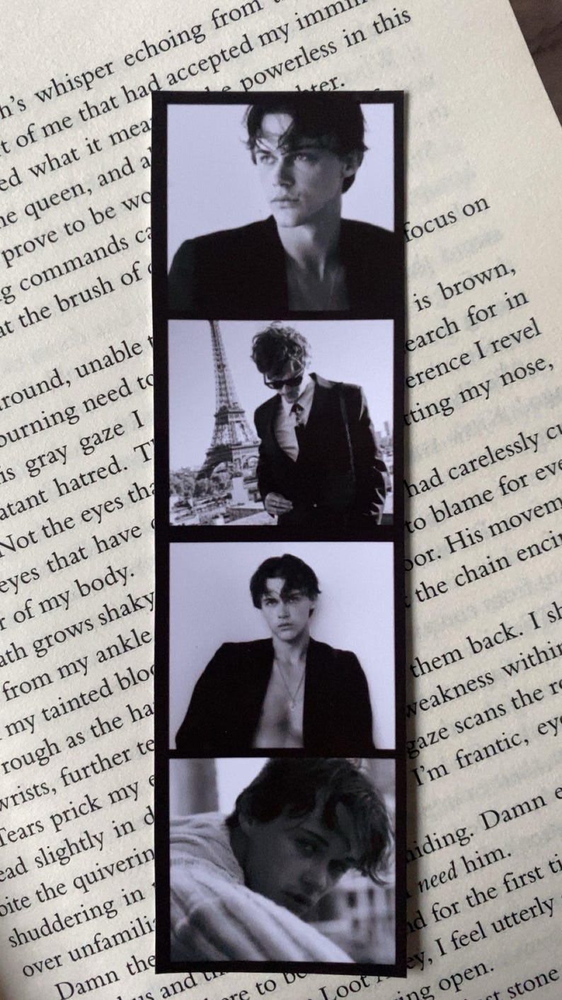 Puede incluir: Marcap&aacute;ginas en blanco y negro con cuatro im&aacute;genes estilo tira de pel&iacute;cula de una persona. Las im&aacute;genes muestran a la persona en varias poses, incluida una con la Torre Eiffel de fondo. El marcap&aacute;ginas es rectangular y tiene un borde negro.