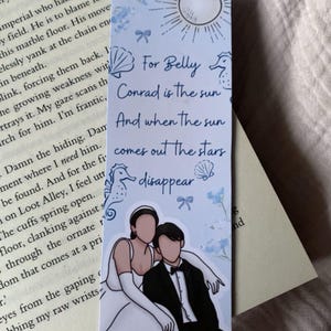 Puede incluir: Marcap&aacute;ginas rectangular con una ilustraci&oacute;n de pareja y texto. El texto dice: "Para Belly, Conrad es el sol, Y cuando sale el sol, las estrellas desaparecen". El marcap&aacute;ginas tiene un esquema de color azul claro y blanco.