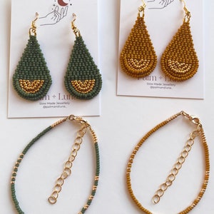 May include: Two pairs of beaded earrings and two beaded bracelets. The earrings are teardrop shaped and have a gold accent. The bracelets are made with green and gold beads. The earrings are on a white background and the bracelets are on a gray background. The text "Palm + Luna Slow Made Jewellery @palmandluna" is on the background.