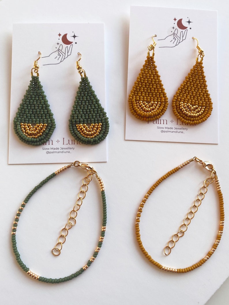 May include: Two pairs of beaded earrings and two beaded bracelets. The earrings are teardrop shaped and have a gold accent. The bracelets are made with green and gold beads. The earrings are on a white background and the bracelets are on a gray background. The text "Palm + Luna Slow Made Jewellery @palmandluna" is on the background.