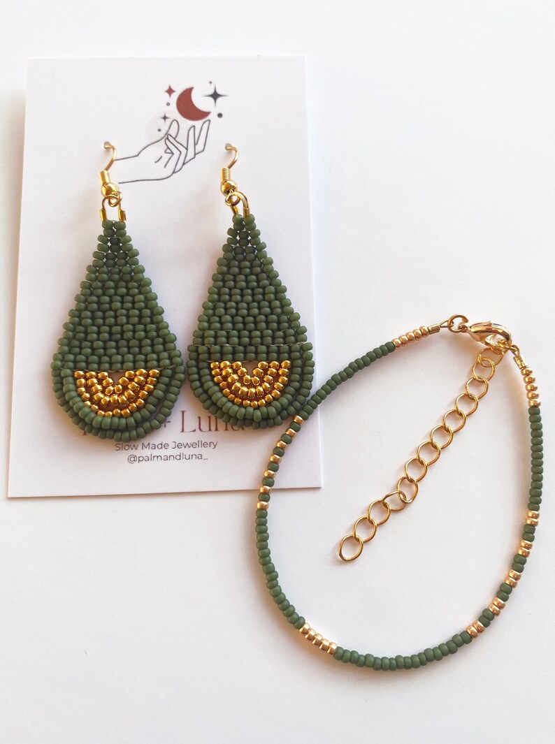 May include: A set of green and gold beaded earrings and a matching bracelet. The earrings are teardrop shaped and the bracelet is delicate. The earrings and bracelet are made with small, round beads.