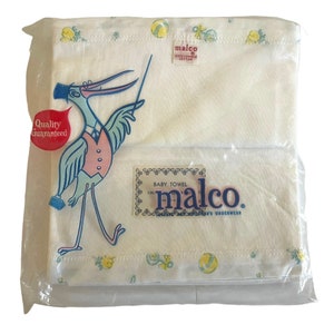 May include: A white baby towel with a blue and white stork illustration and the text "Malco Baby Towel 100% Cotton Infants Underwear" in a blue and white border.