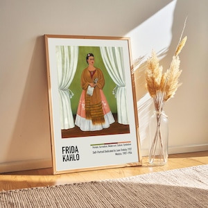 May include: A framed print of a self-portrait by Frida Kahlo. The painting depicts Frida in a traditional Mexican dress, standing in front of a green background with white curtains. The text below the painting reads "Self-Portrait Dedicated to Leon Trotsky 1937 Mexico, 1907-1954".