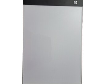 May include: A black framed light pad with a white surface and a small black button on the top right corner. The button has a white circle with a letter C inside.