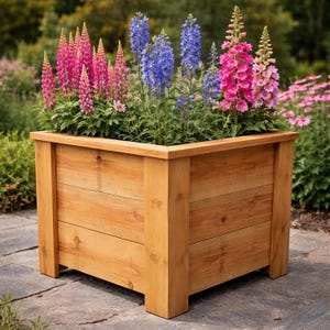 Può includere: Una fioriera in legno piena di fiori vibranti. La scatola è fatta di legno chiaro e ha una forma rettangolare. I fiori includono fiori rosa, blu e viola, creando un'esposizione colorata. La fioriera è posta su una superficie di pietra, con verde sullo sfondo.