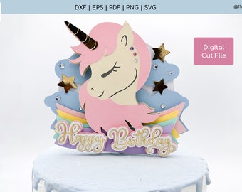 May include: A pink unicorn head with a gold horn and a rainbow layered cake topper with the words "Happy Birthday".