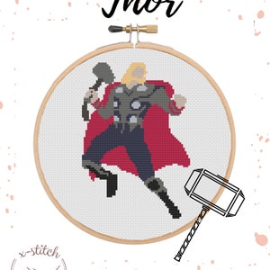 May include: Cross-stitch pattern of Thor, a superhero from Marvel Comics, holding his hammer, Mjolnir. The pattern is in a circular embroidery hoop with a wooden frame. The background is white with pink dots.