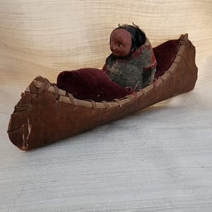 Antique Skookum in canoe