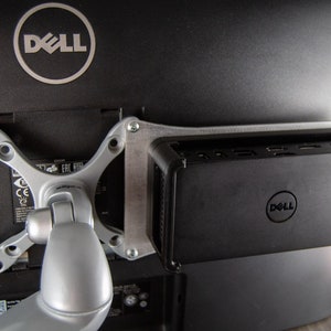 May include: A Dell monitor with a Dell computer mounted to the back. The monitor is attached to a silver arm.