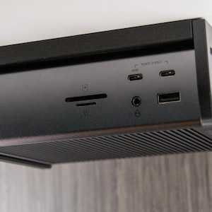 Op de afbeelding: Een zwarte CalDigit docking station met meerdere poorten, waaronder USB, Thunderbolt en audio. Het apparaat heeft een strak, modern ontwerp met een geribbelde onderkant voor ventilatie. Het CalDigit-logo is zichtbaar.