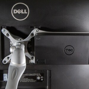 May include: A black Dell monitor with a silver adjustable arm attached to the back. A black Dell docking station is attached to the back of the monitor.