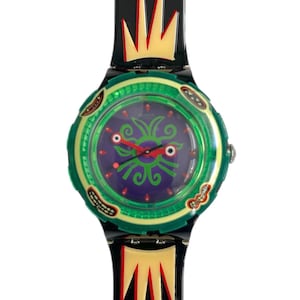 May include: A black and green Swatch watch with a purple face and a red and yellow design on the band. The watch face features a stylized green and purple creature with red eyes.