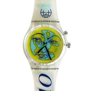 Op de afbeelding: Een transparant plastic polshorloge met een gele wijzerplaat en een blauw en groen globe-ontwerp. De horlogeband heeft het woord "GLOBE" in blauw erop gedrukt.