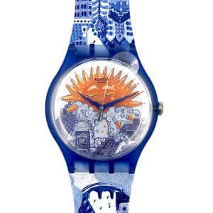 Può includere: Un orologio Swatch blu con un design a paesaggio urbano sul cinturino e sul quadrante. Il quadrante dell'orologio presenta un sole sorridente con nuvole ed edifici. Il cinturino e la cassa dell'orologio sono blu e l'orologio ha un'etichetta svizzera.