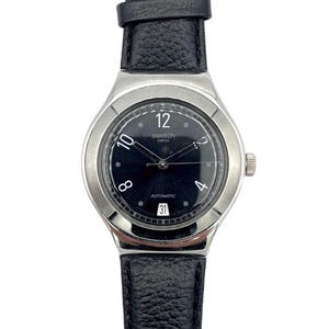 May include: A Swatch Swiss automatic watch with a black dial, silver case, and black leather strap. The watch face shows the numbers 4, 8, 10, and 12, with the date at the 3 o'clock position. The watch has a silver crown.