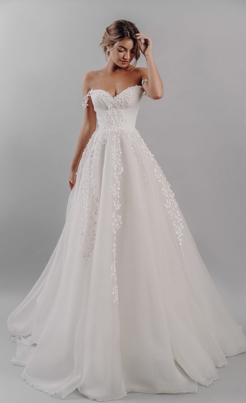 Gentle off-shoulder A-line wedding dress. Simple wedding dress image 1