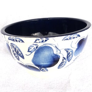 May include: A white ceramic bowl with a blue and white floral design. The bowl has a dark blue interior.