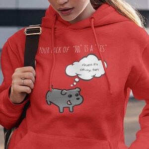May include: Red hooded sweatshirt with a cartoon dog and the text "YOUR LACK OF "NO" IS A "YES" and "Guess it's okay then" in a thought bubble.