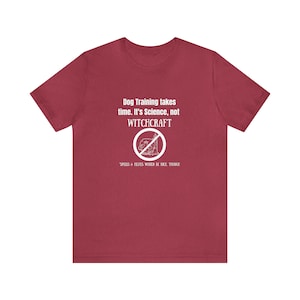 May include: Red t-shirt with white text that reads "Dog Training takes time. It's Science, not WITCHCRAFT. SPELLS & HEXES WOULD BE NICE THOUGH."