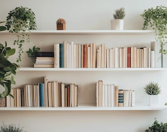 May include: White bookshelf with three shelves filled with books and potted plants. The top shelf has a small decorative object on the left side. The middle shelf is filled with books, and the bottom shelf has a few books on the left side and a potted plant on the right side.