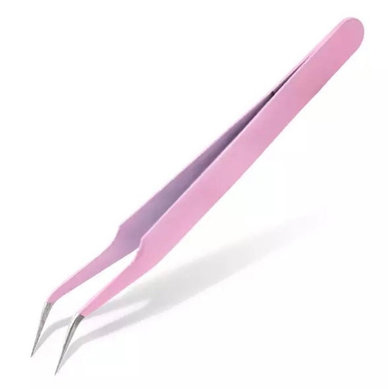 May include: Pink metal tweezers with slanted tips. The tweezers are designed for precision work, such as applying false eyelashes.