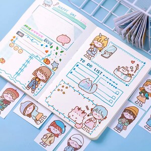 以下が含まれることがあります： 青と白のプランナーで、やることリストとメモ欄があります。プランナーは、キャラクターと動物のかわいい漫画のデザインです。青い背景に漫画のキャラクターのステッカーもいくつかあります。