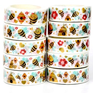May include: Ten rolls of washi tape with a bee theme. The tape is white with gold glitter and features bees, honeycombs, flowers, and hearts.