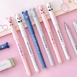 May include: Set of eight pens with cute animal designs on the caps. The pens are pink, white, and blue with black ink. The pens have Chinese characters printed on them.