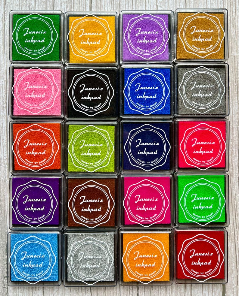May include: A set of 16 colorful ink pads with a white circle and the text "Junesix inkpad design by Junesix" in the center of each pad.