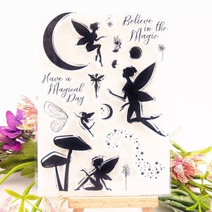 May include: Clear stamp sheet with fairy silhouettes, stars, moons, mushrooms, and the text "Believe in the Magic" and "Have a Magical Day".