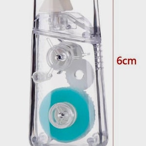 May include: A clear plastic tape dispenser with a blue tape roll. The dispenser is 6 inches tall and 3 inches wide.