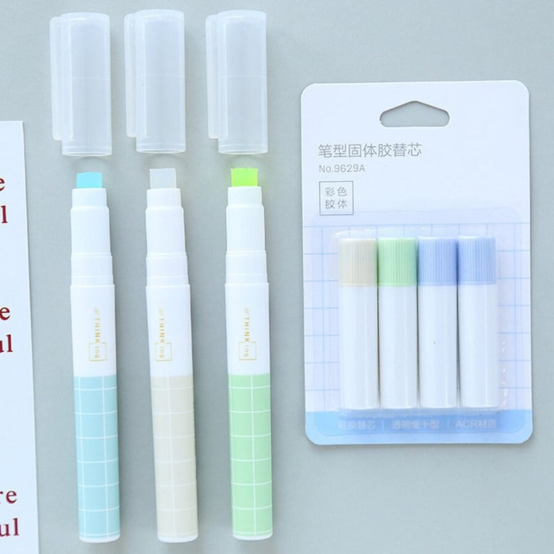 Puede incluir: Conjunto de cuatro recambios de pegamento s&oacute;lido en azul, beige, verde y azul claro. Los recambios est&aacute;n en una caja de pl&aacute;stico transparente con una etiqueta blanca que dice "笔型固体胶替芯 No.9629A 彩色 胶体" y "可換替芯週明慢干型 | ACR材质".