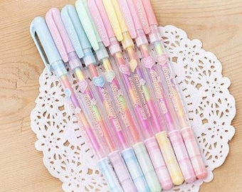 May include: A set of ten pastel colored gel pens with rainbow glitter ink. The pens have a checkered pattern and say "Rainbow Pen" on the barrel.