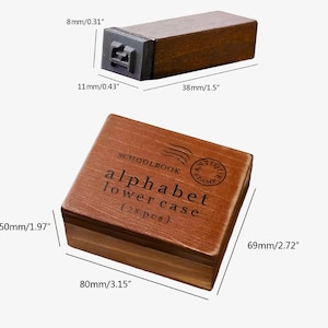 May include: A wooden box containing 28 lowercase alphabet stamps. The box is brown with a label that reads "SCHOOLBOOK ANTIQUE STAMP alphabet lowercase (28 pcs)". The box measures 3.15 inches by 2.72 inches by 1.97 inches.
