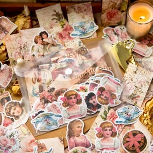 May include: A sheet of vintage-style stickers featuring images of children, flowers, and teacups. The stickers are printed on white paper and have a distressed, antique look.
