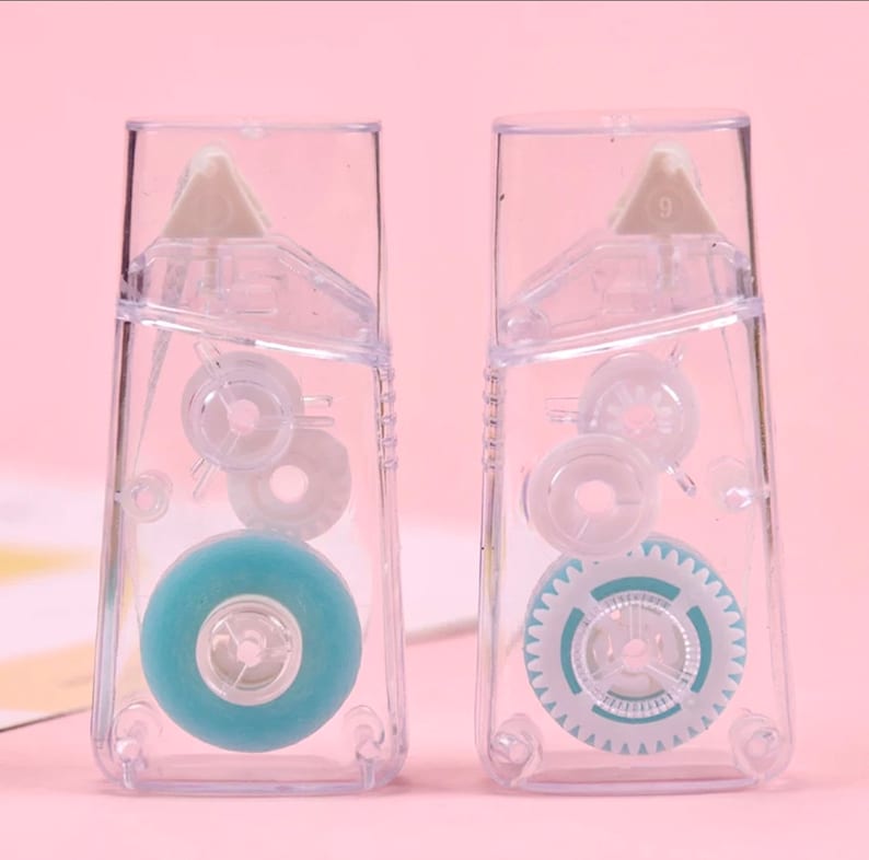 May include: Two clear plastic tape dispensers with blue tape rolls. The dispensers have a gear mechanism and a clear plastic cover.
